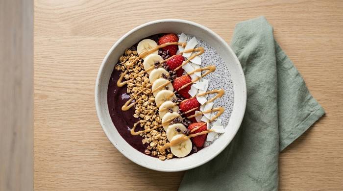Muz, çilek, granola ve chia tohumuyla süslenmiş açai bowl